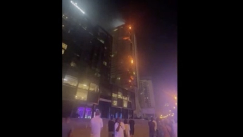 Kebakaran terjadi di gedung dekat dengan Burj Khalifa, gedung tertinggi di dunia, terlihat di belakangnya di Dubai, Uni Emirat Arab, Senin, 7 November 2022. (Tangkapan Layar Video/ Romanna Dada via Reuters)
