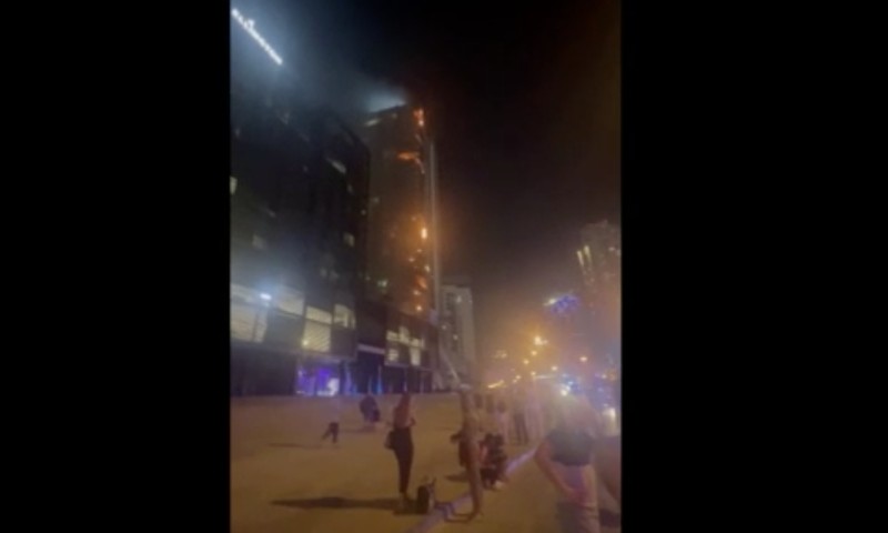 Kebakaran terjadi di gedung dekat dengan Burj Khalifa, gedung tertinggi di dunia, terlihat di belakangnya di Dubai, Uni Emirat Arab, Senin, 7 November 2022. (Tangkapan Layar Video/ Romanna Dada via Reuters)
