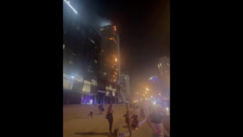 Kebakaran terjadi di gedung dekat dengan Burj Khalifa, gedung tertinggi di dunia, terlihat di belakangnya di Dubai, Uni Emirat Arab, Senin, 7 November 2022. (Tangkapan Layar Video/ Romanna Dada via Reuters)
