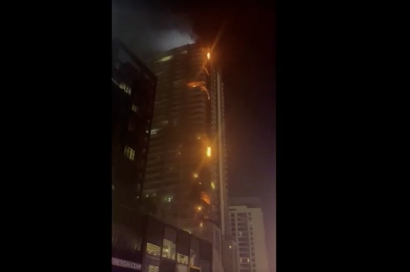 Kebakaran terjadi di gedung dekat dengan Burj Khalifa, gedung tertinggi di dunia, terlihat di belakangnya di Dubai, Uni Emirat Arab, Senin, 7 November 2022. (Tangkapan Layar Video/ Romanna Dada via Reuters)