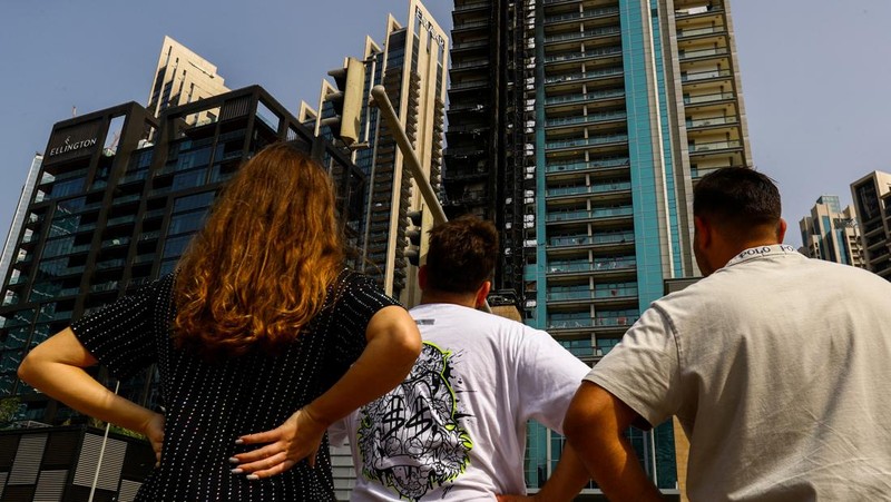 Kebakaran terjadi di gedung dekat dengan Burj Khalifa, gedung tertinggi di dunia, terlihat di belakangnya di Dubai, Uni Emirat Arab, Senin, 7 November 2022. (Tangkapan Layar Video/ Romanna Dada via Reuters)