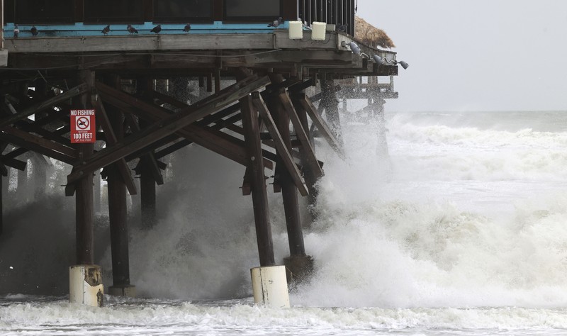 DAYTONA BEACH SHORES, UNITED STATES - 2022/11/09: Waves crash near a damaged building and a lifeguard tower in Daytona Beach Shores in Florida, as tropical Storm Nicole approaches the coast of Florida with an expected landfall as a category one hurricane. (Photo by Paul Hennessy/SOPA Images/LightRocket via Getty Images)