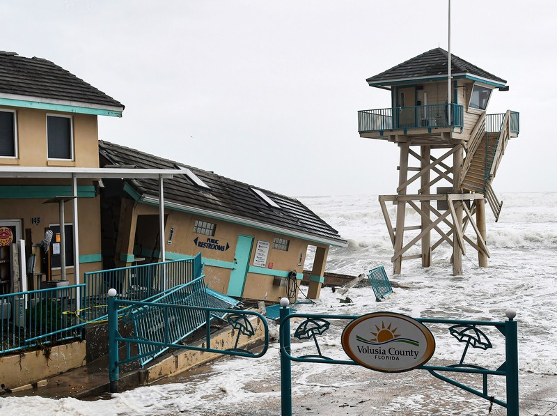DAYTONA BEACH SHORES, UNITED STATES - 2022/11/09: Waves crash near a damaged building and a lifeguard tower in Daytona Beach Shores in Florida, as tropical Storm Nicole approaches the coast of Florida with an expected landfall as a category one hurricane. (Photo by Paul Hennessy/SOPA Images/LightRocket via Getty Images)