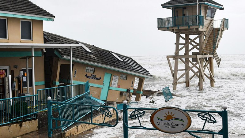 DAYTONA BEACH SHORES, UNITED STATES - 2022/11/09: Waves crash near a damaged building and a lifeguard tower in Daytona Beach Shores in Florida, as tropical Storm Nicole approaches the coast of Florida with an expected landfall as a category one hurricane. (Photo by Paul Hennessy/SOPA Images/LightRocket via Getty Images)