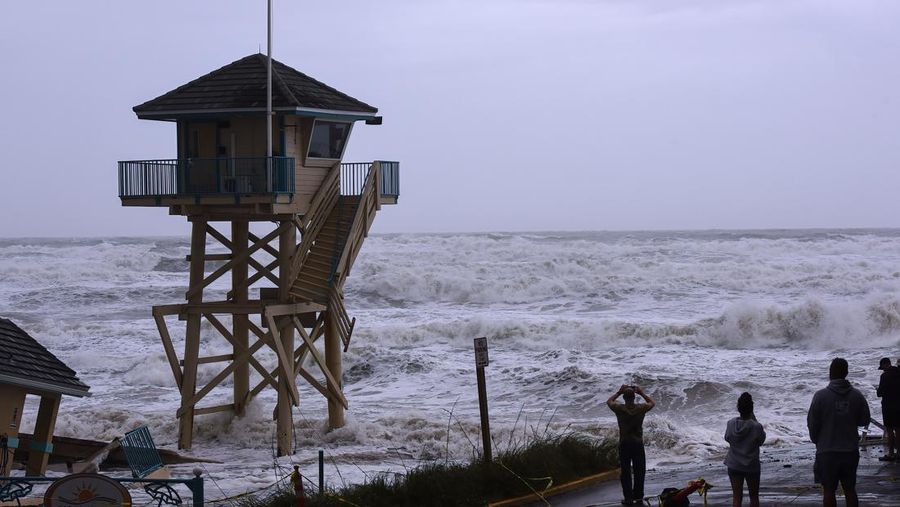 DAYTONA BEACH SHORES, UNITED STATES - 2022/11/09: Waves crash near a damaged building and a lifeguard tower in Daytona Beach Shores in Florida, as tropical Storm Nicole approaches the coast of Florida with an expected landfall as a category one hurricane. (Photo by Paul Hennessy/SOPA Images/LightRocket via Getty Images)