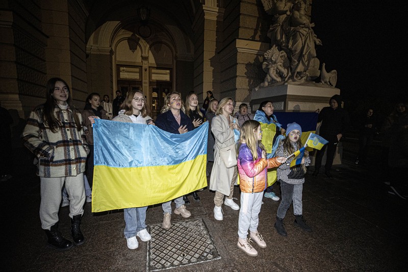 A man holds a Ukranian flag as people gather in Maidan Square to celebrate the liberation of Kherson, in Kyiv on November 11, 2022, amid the Russian invasion of Ukraine. - Ukraine's President Volodymyr Zelensky said on November 11 that Kherson was 