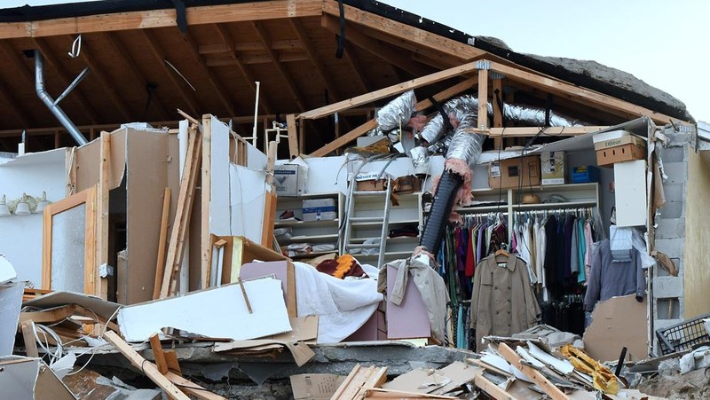 WILBUR-BY-THE-SEA, FLORIDA, UNITED STATES - NOVEMBER 11: A man walks past homes that collapsed onto the beach due to the storm surge and resulting erosion caused by Hurricane Nicole on November 11, 2022 in Wilbur-By-The-Sea, Florida. Nicole made landfall as a Category 1 hurricane before weakening into a tropical storm. (Photo by Paul Hennessy/Anadolu Agency via Getty Images)