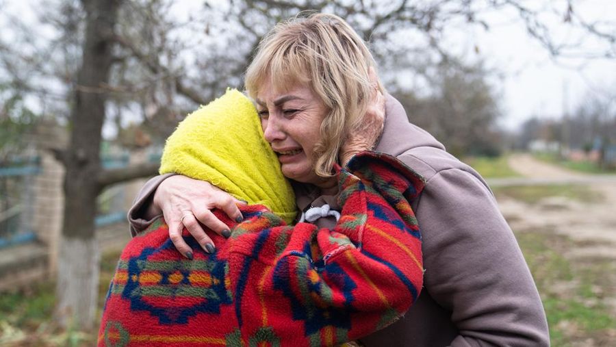 People hold Ukrainian flags as they gather to celebrate the liberation of their town in Kherson, on November 12, 2022, amid Russia's invasion of Ukraine. - On November 11, 2022, Russia said it had pulled back more than 30,000 troops in the southern region, with Ukrainian President Volodymyr Zelensky declaring Kherson 
