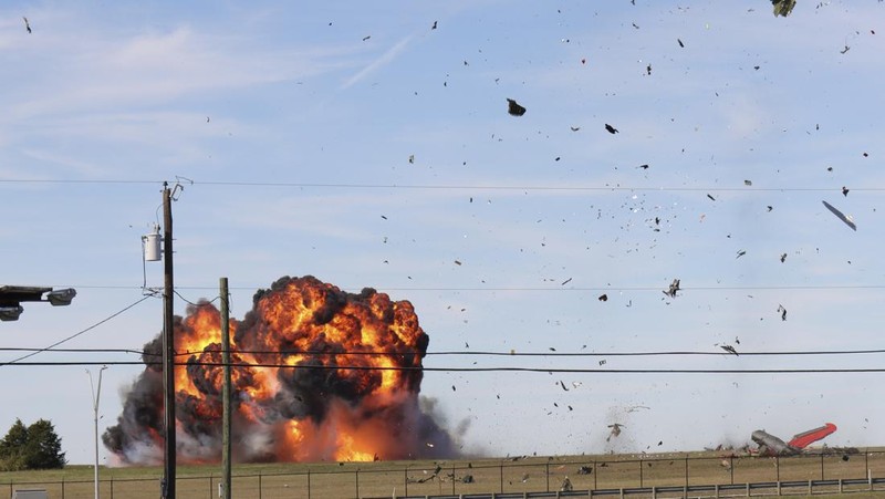 In this photo provided by Nathaniel Ross Photography, a historic military plane crashes after colliding with another plane during an airshow at Dallas Executive Airport in Dallas on Saturday, Nov. 12, 2022. (Nathaniel Ross Photography via AP)