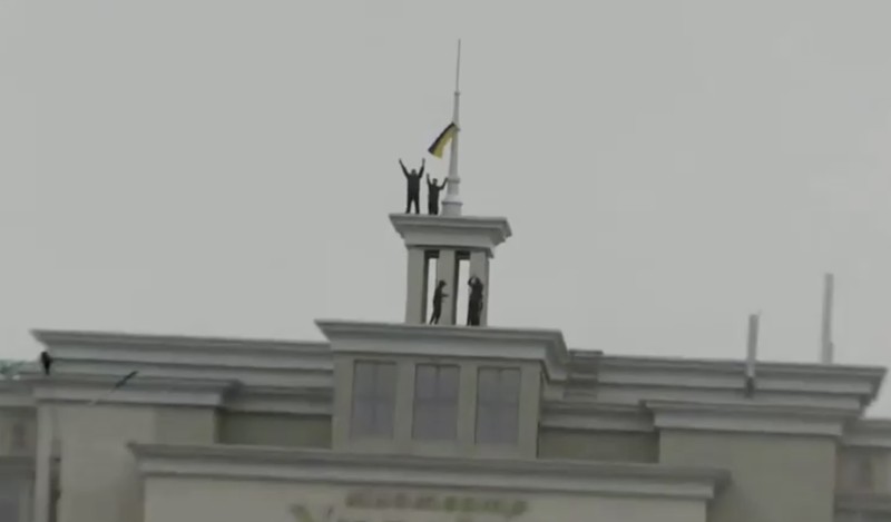 A man holds a Ukranian flag as people gather in Maidan Square to celebrate the liberation of Kherson, in Kyiv on November 11, 2022, amid the Russian invasion of Ukraine. - Ukraine's President Volodymyr Zelensky said on November 11 that Kherson was 