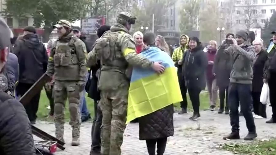 A man holds a Ukranian flag as people gather in Maidan Square to celebrate the liberation of Kherson, in Kyiv on November 11, 2022, amid the Russian invasion of Ukraine. - Ukraine's President Volodymyr Zelensky said on November 11 that Kherson was 