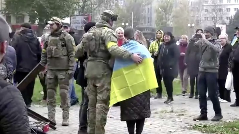 A man holds a Ukranian flag as people gather in Maidan Square to celebrate the liberation of Kherson, in Kyiv on November 11, 2022, amid the Russian invasion of Ukraine. - Ukraine's President Volodymyr Zelensky said on November 11 that Kherson was 