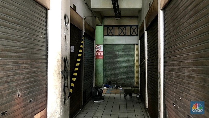 Pengunjnung melintas di depan kios yang tutul di pasar Mampang, Senin (14/112/2022). Sepinya pengunjung di Pasar Mampang membuat para pedagang  memilih menjual atau menyewakan kiosnya. (CNBC Indonesia/Andrean Kristianto)