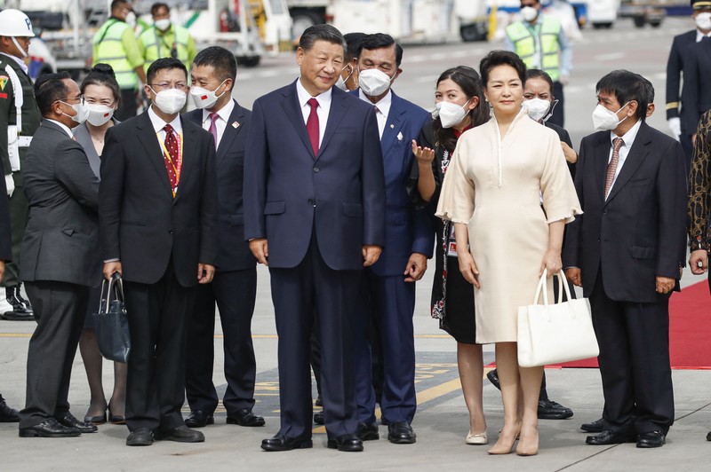 Presiden China Xi Jinping bersama istrinya Peng Liyuan tiba di bandara Internasional Ngurah Rai di Denpasar di pulau resor Indonesia Bali, 14/11/2022. Kelompok Dua Puluh (G20) ke-17 Kepala State and Government Summit akan diadakan di Bali pada 15-16 November 2022. (Foto oleh AJENG DINAR ULFIANA / POOL / AFP)
