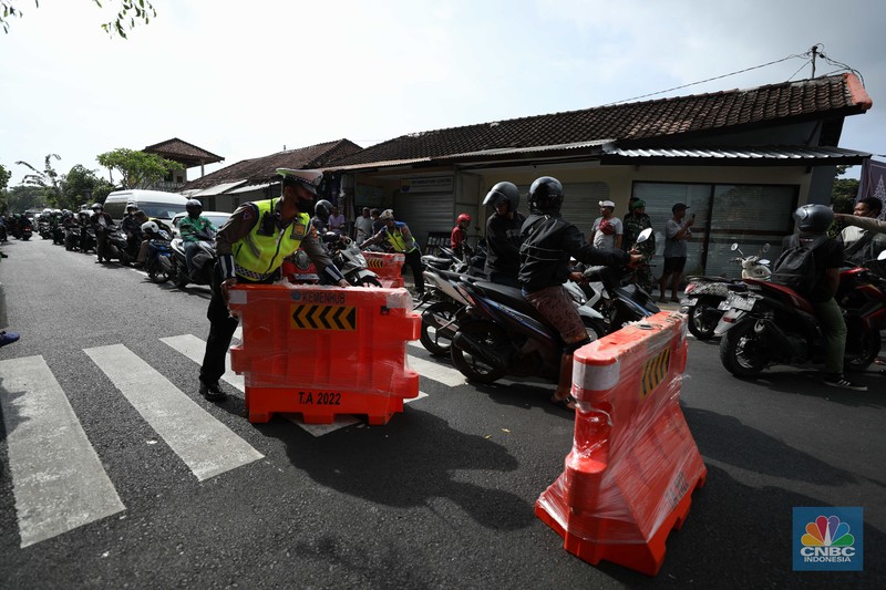 Petugas kepolisan menutup Jl.Utama I Gusti Ngurah Rai, Badung, Bali pada Selasa (15/11/2022). Korp Lalu Lintas (Korlantas) Polri melakukan penutupan dan pengalihan arus lalu lintas (lalin) di sejumlah ruas jalan di Bali, hari ini. (CNBC Indonesia/Tri Susilo)