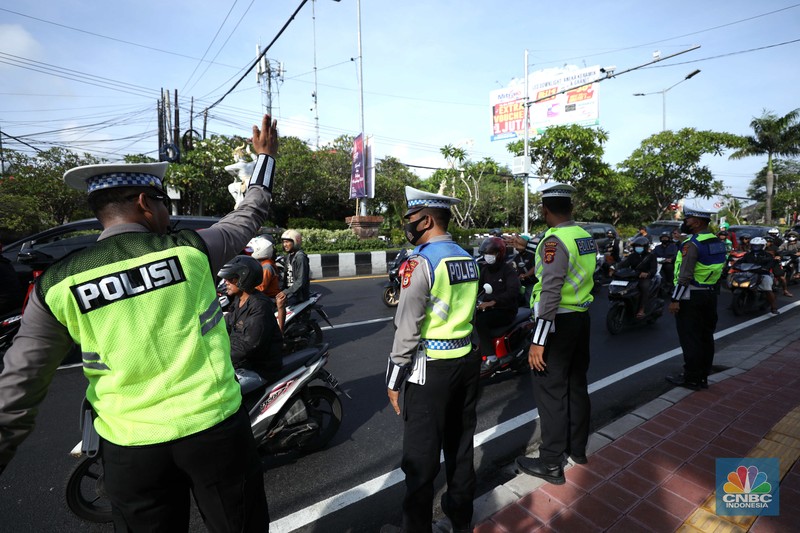 Petugas kepolisan menutup Jl.Utama I Gusti Ngurah Rai, Badung, Bali pada Selasa (15/11/2022). Korp Lalu Lintas (Korlantas) Polri melakukan penutupan dan pengalihan arus lalu lintas (lalin) di sejumlah ruas jalan di Bali, hari ini. (CNBC Indonesia/Tri Susilo)