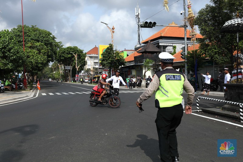 Petugas kepolisan menutup Jl.Utama I Gusti Ngurah Rai, Badung, Bali pada Selasa (15/11/2022). Korp Lalu Lintas (Korlantas) Polri melakukan penutupan dan pengalihan arus lalu lintas (lalin) di sejumlah ruas jalan di Bali, hari ini. (CNBC Indonesia/Tri Susilo)