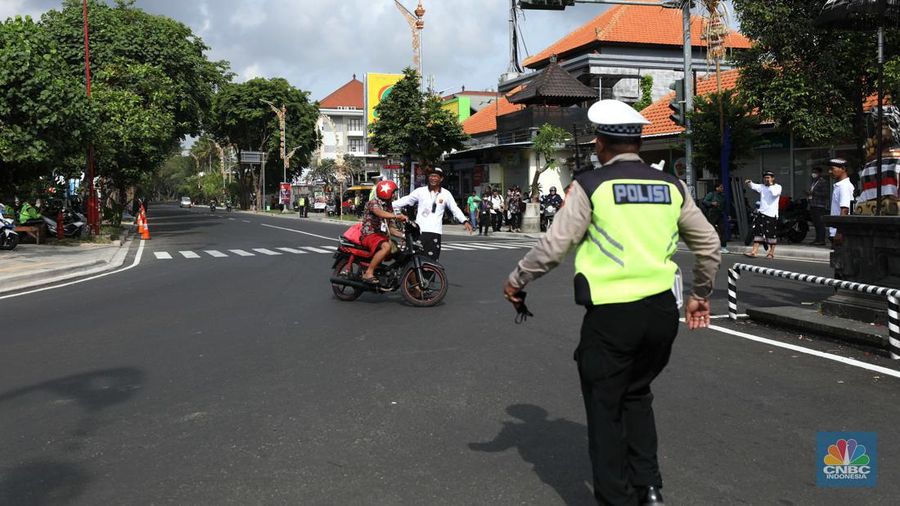 Petugas kepolisan menutup Jl.Utama I Gusti Ngurah Rai, Badung, Bali pada Selasa (15/11/2022). Korp Lalu Lintas (Korlantas) Polri melakukan penutupan dan pengalihan arus lalu lintas (lalin) di sejumlah ruas jalan di Bali, hari ini. (CNBC Indonesia/Tri Susilo)