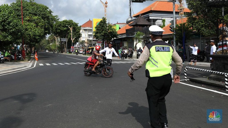 Petugas kepolisan menutup Jl.Utama I Gusti Ngurah Rai, Badung, Bali pada Selasa (15/11/2022). Korp Lalu Lintas (Korlantas) Polri melakukan penutupan dan pengalihan arus lalu lintas (lalin) di sejumlah ruas jalan di Bali, hari ini. (CNBC Indonesia/Tri Susilo)