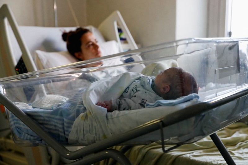 WORLD-POPULATION/ITALY-MATERNITY Newborn baby Leonardo rests on his mum's Viviana Valente arms, inside a room of the Santo Spirito Hospital, as the UN forecasts the world will reach 8 billion people around November 15, 2022, in Rome, Italy, November 14, 2022. REUTERS/Remo Casilli TPX IMAGES OF THE DAY