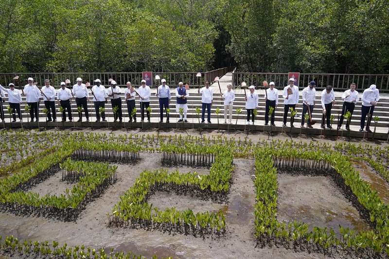 Leaders raise their garden hoes for a group photo during a tree planting event at the Taman Hutan Raya Ngurah Rai Mangrove Forest, on the sidelines of the G20 summit meeting, Wednesday, Nov. 16, 2022, in Denpasar, Bali, Indonesia. (AP Photo/Alex Brandon, Pool)