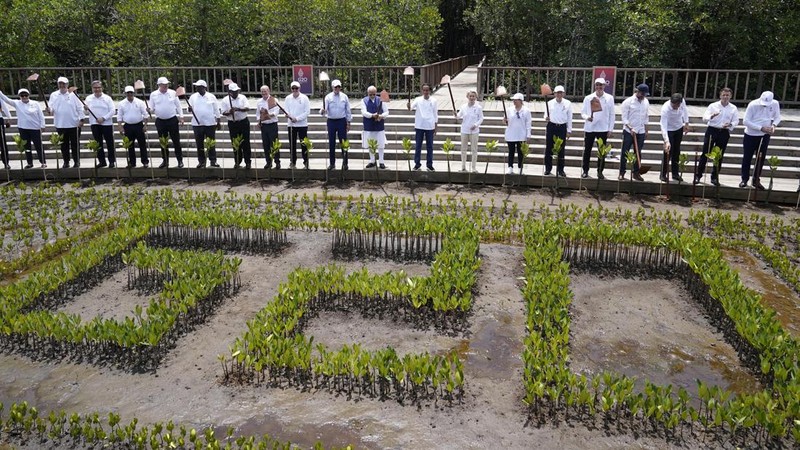 Leaders raise their garden hoes for a group photo during a tree planting event at the Taman Hutan Raya Ngurah Rai Mangrove Forest, on the sidelines of the G20 summit meeting, Wednesday, Nov. 16, 2022, in Denpasar, Bali, Indonesia. (AP Photo/Alex Brandon, Pool)