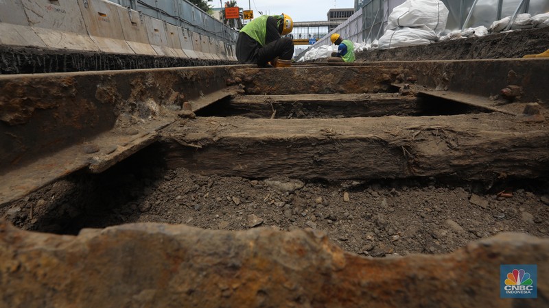 Penemuan Rel Trem di Proyek MRT Fase 2 Sejumlah pekerja melakukan proses relokasi temuan rel trem peninggalan zaman kolonial Belanda pada proyek MRT Jakarta fase 2A CP 202 di Jalan Gajah Mada, Jakarta , Rabu (16/11/2022). Objek cagar budaya berusia lebih dari 100 tahun tersebut diperkirakan dibangun pada tahun 1869 dan merupakan rel kereta tertua di Indonesia dan akan direlokasi sementara ke storage pool PPD Jelambar. (CNBC Indonesia/ Andrean Kristianto)