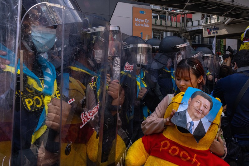 BANGKOK, THAILAND - NOVEMBER 17: A protester carries a Winnie the Pooh teddy bear representing Xi Jinping next to riot police during a demonstration nearby the site of the Asia-Pacific Economic Cooperation (APEC) summit on November 17, 2022 in Bangkok, Thailand. Thailand is hosting the APEC meetings this year, which will culminate in the leaders' meetings which will run from Nov. 17 to 19. (Photo by Louise Delmotte/Getty Images)