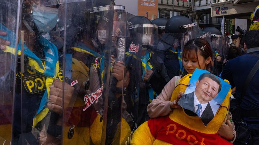 BANGKOK, THAILAND - NOVEMBER 17: A protester carries a Winnie the Pooh teddy bear representing Xi Jinping next to riot police during a demonstration nearby the site of the Asia-Pacific Economic Cooperation (APEC) summit on November 17, 2022 in Bangkok, Thailand. Thailand is hosting the APEC meetings this year, which will culminate in the leaders' meetings which will run from Nov. 17 to 19. (Photo by Louise Delmotte/Getty Images)