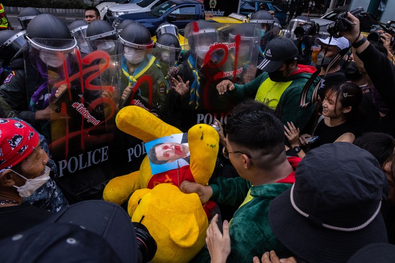 BANGKOK, THAILAND - NOVEMBER 17: A protester carries a Winnie the Pooh teddy bear representing Xi Jinping next to riot police during a demonstration nearby the site of the Asia-Pacific Economic Cooperation (APEC) summit on November 17, 2022 in Bangkok, Thailand. Thailand is hosting the APEC meetings this year, which will culminate in the leaders' meetings which will run from Nov. 17 to 19. (Photo by Louise Delmotte/Getty Images)