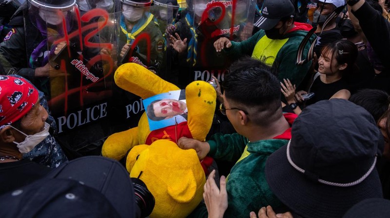 BANGKOK, THAILAND - NOVEMBER 17: A protester carries a Winnie the Pooh teddy bear representing Xi Jinping next to riot police during a demonstration nearby the site of the Asia-Pacific Economic Cooperation (APEC) summit on November 17, 2022 in Bangkok, Thailand. Thailand is hosting the APEC meetings this year, which will culminate in the leaders' meetings which will run from Nov. 17 to 19. (Photo by Louise Delmotte/Getty Images)