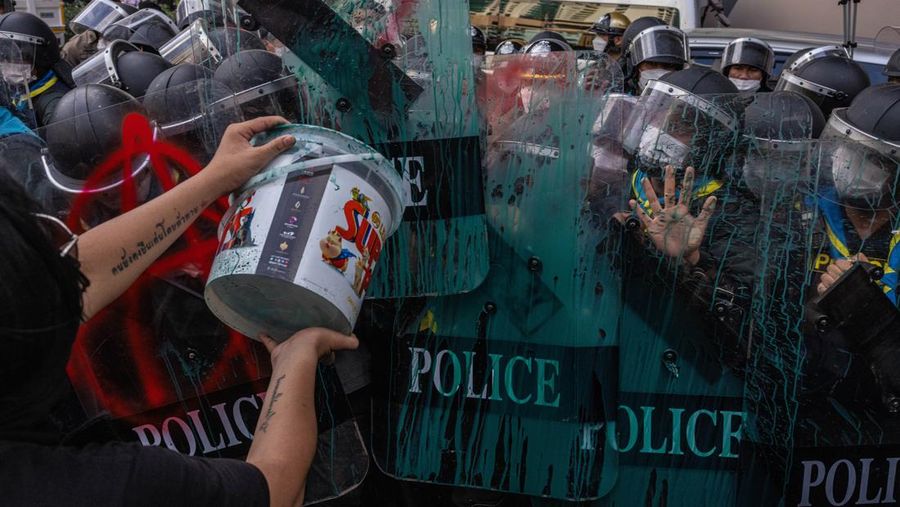 BANGKOK, THAILAND - NOVEMBER 17: Protesters throw paint on riot police during a demonstration nearby the site of the Asia-Pacific Economic Cooperation (APEC) summit on November 17, 2022 in Bangkok, Thailand. Thailand is hosting the APEC meetings this year, which will culminate in the leaders' meetings which will run from Nov. 17 to 19. (Photo by Louise Delmotte/Getty Images)