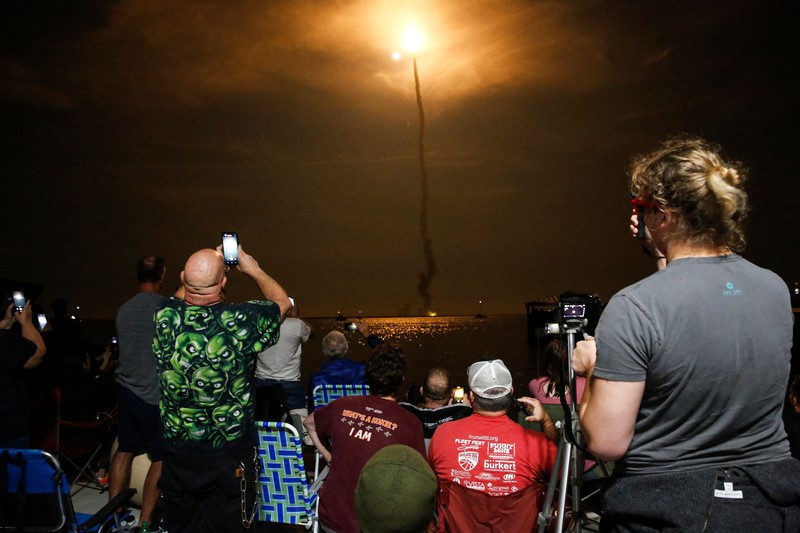 Artemis 1 mengirimkan pesawat ruang angkasa Orion baru NASA dalam uji terbang tanpa awak mengelilingi bulan. People at Veterans Memorial park watch as the Artemis I unmanned lunar rocket lifts off from launch pad 39B at NASA's Kennedy Space Center, in Titusville, Florida, on November 16, 2022. - NASA's Artemis 1 mission is a 25-and-a-half day voyage beyond the far side of the Moon and back. The meticulously choreographed uncrewed flight should yield spectacular images as well as valuable scientific data. (Photo by Marco BELLO / AFP) (Photo by MARCO BELLO/AFP via Getty Images)
