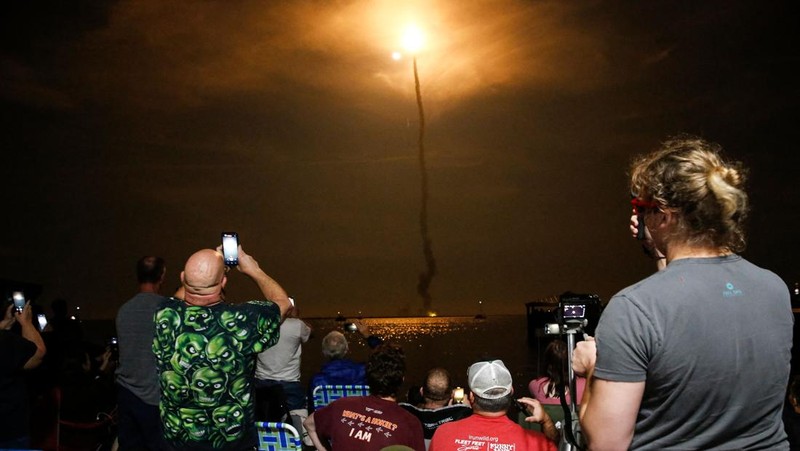 People at Veterans Memorial park watch as the Artemis I unmanned lunar rocket lifts off from launch pad 39B at NASA's Kennedy Space Center, in Titusville, Florida, on November 16, 2022. - NASA's Artemis 1 mission is a 25-and-a-half day voyage beyond the far side of the Moon and back. The meticulously choreographed uncrewed flight should yield spectacular images as well as valuable scientific data. (Photo by Marco BELLO / AFP) (Photo by MARCO BELLO/AFP via Getty Images)