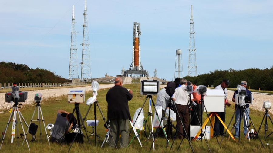 People at Veterans Memorial park watch as the Artemis I unmanned lunar rocket lifts off from launch pad 39B at NASA's Kennedy Space Center, in Titusville, Florida, on November 16, 2022. - NASA's Artemis 1 mission is a 25-and-a-half day voyage beyond the far side of the Moon and back. The meticulously choreographed uncrewed flight should yield spectacular images as well as valuable scientific data. (Photo by Marco BELLO / AFP) (Photo by MARCO BELLO/AFP via Getty Images)