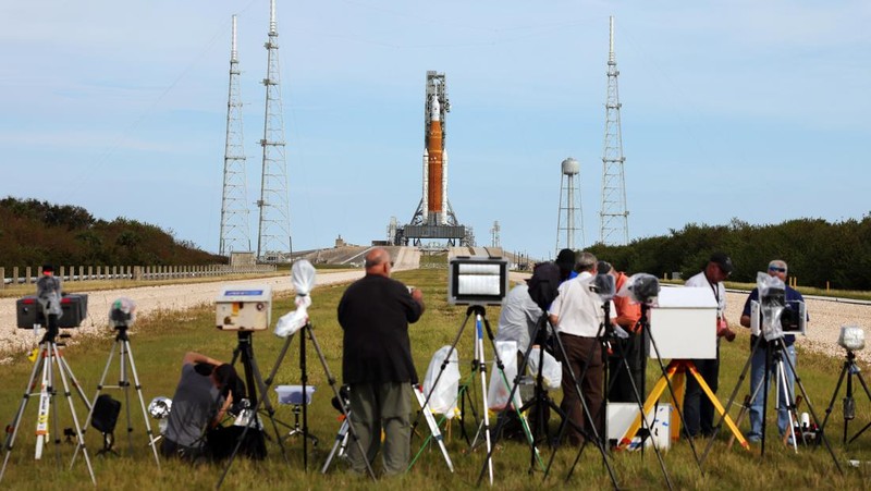 People at Veterans Memorial park watch as the Artemis I unmanned lunar rocket lifts off from launch pad 39B at NASA's Kennedy Space Center, in Titusville, Florida, on November 16, 2022. - NASA's Artemis 1 mission is a 25-and-a-half day voyage beyond the far side of the Moon and back. The meticulously choreographed uncrewed flight should yield spectacular images as well as valuable scientific data. (Photo by Marco BELLO / AFP) (Photo by MARCO BELLO/AFP via Getty Images)