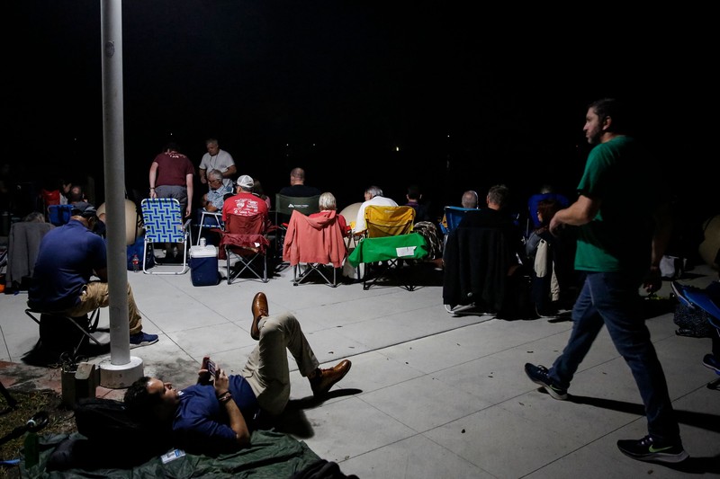 Artemis 1 mengirimkan pesawat ruang angkasa Orion baru NASA dalam uji terbang tanpa awak mengelilingi bulan. People at Veterans Memorial park watch as the Artemis I unmanned lunar rocket lifts off from launch pad 39B at NASA's Kennedy Space Center, in Titusville, Florida, on November 16, 2022. - NASA's Artemis 1 mission is a 25-and-a-half day voyage beyond the far side of the Moon and back. The meticulously choreographed uncrewed flight should yield spectacular images as well as valuable scientific data. (Photo by Marco BELLO / AFP) (Photo by MARCO BELLO/AFP via Getty Images)