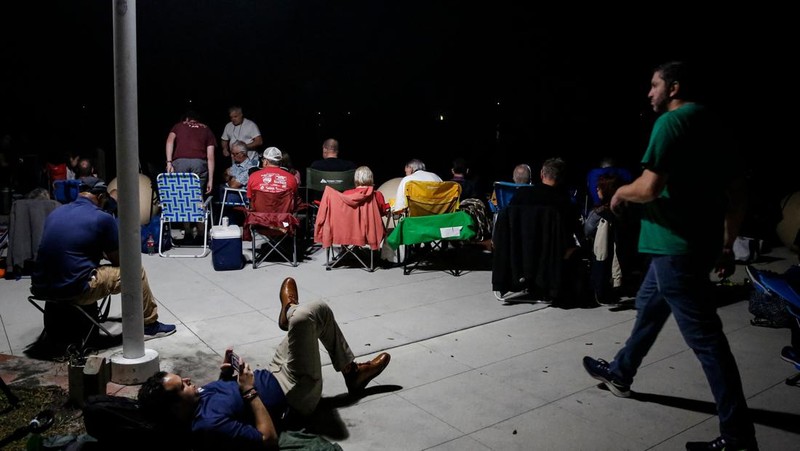 People at Veterans Memorial park watch as the Artemis I unmanned lunar rocket lifts off from launch pad 39B at NASA's Kennedy Space Center, in Titusville, Florida, on November 16, 2022. - NASA's Artemis 1 mission is a 25-and-a-half day voyage beyond the far side of the Moon and back. The meticulously choreographed uncrewed flight should yield spectacular images as well as valuable scientific data. (Photo by Marco BELLO / AFP) (Photo by MARCO BELLO/AFP via Getty Images)