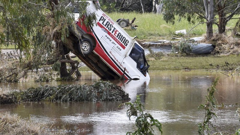 One of the many vehicles swept away during a flash flood, sits embedded in a tree in the town of Eugowra, Central West New South Wales, Tuesday, Nov. 15, 2022. A rare third consecutive La Niña weather pattern, which is associated with above-average rainfall in eastern Australia, has created a flooding emergency across large swathes of New South Wales that has lasted for two months.(Murray McCloskey/AAP Image via AP)