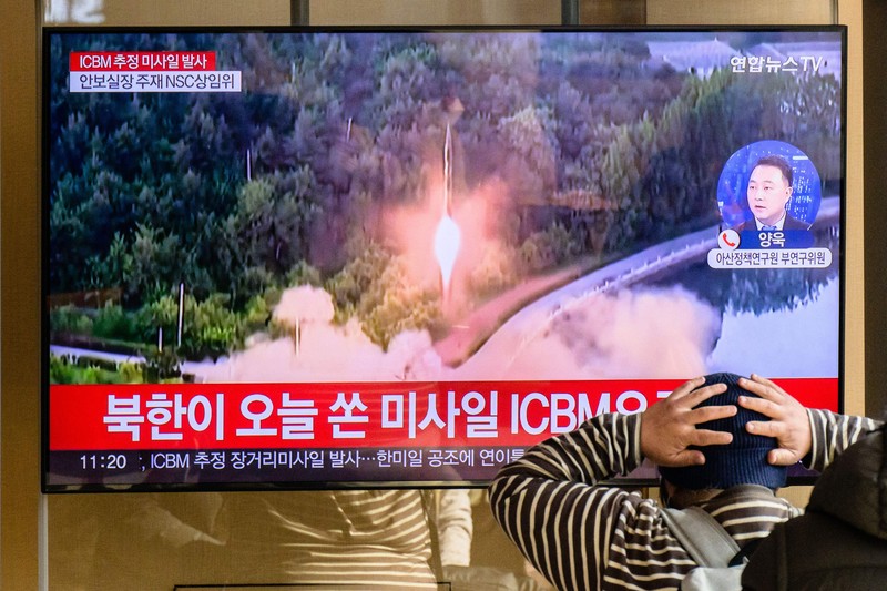 TOPSHOT - A man watches a television showing a news broadcast with file footage of a North Korean missile test, at a railway station in Seoul on November 18, 2022. - A suspected intercontinental ballistic missile launched by North Korea on Friday is believed to have fallen in Japan's exclusive economic waters, Japanese Prime Minister Fumio Kishida said. (Photo by Anthony WALLACE / AFP) (Photo by ANTHONY WALLACE/AFP via Getty Images)