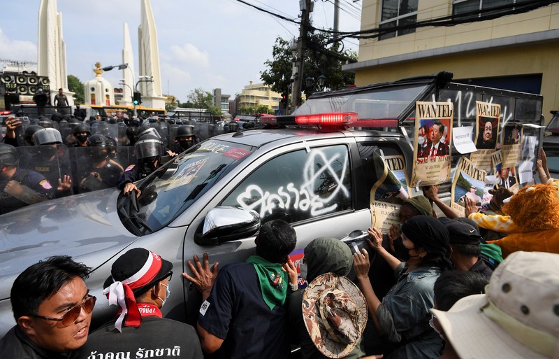 Para demonstran anti-pemerintah kembali bentrok dengan polisi anti huru-hara dalam rangka menolak aktivitas KTT APEC di Bangkok. Demonstrators push a vehicle as police officers with shields stand guard near them during a protest against the Asia-Pacific Economic Cooperation (APEC) Summit 2022, near the Democracy Monument in Bangkok, Thailand November 18, 2022. REUTERS/Chalinee Thirasupa