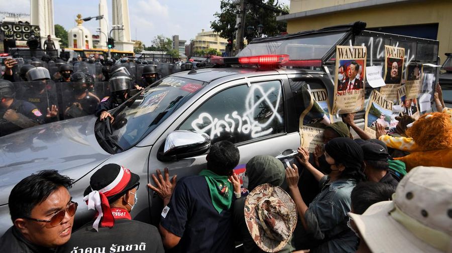 Demonstrators push a vehicle as police officers with shields stand guard near them during a protest against the Asia-Pacific Economic Cooperation (APEC) Summit 2022, near the Democracy Monument in Bangkok, Thailand November 18, 2022. REUTERS/Chalinee Thirasupa
