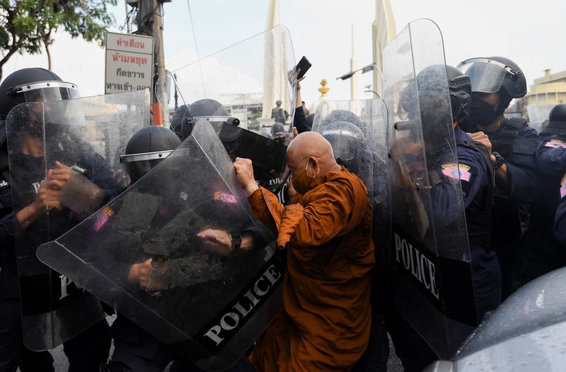 Para demonstran anti-pemerintah kembali bentrok dengan polisi anti huru-hara dalam rangka menolak aktivitas KTT APEC di Bangkok. Demonstrators push a vehicle as police officers with shields stand guard near them during a protest against the Asia-Pacific Economic Cooperation (APEC) Summit 2022, near the Democracy Monument in Bangkok, Thailand November 18, 2022. REUTERS/Chalinee Thirasupa