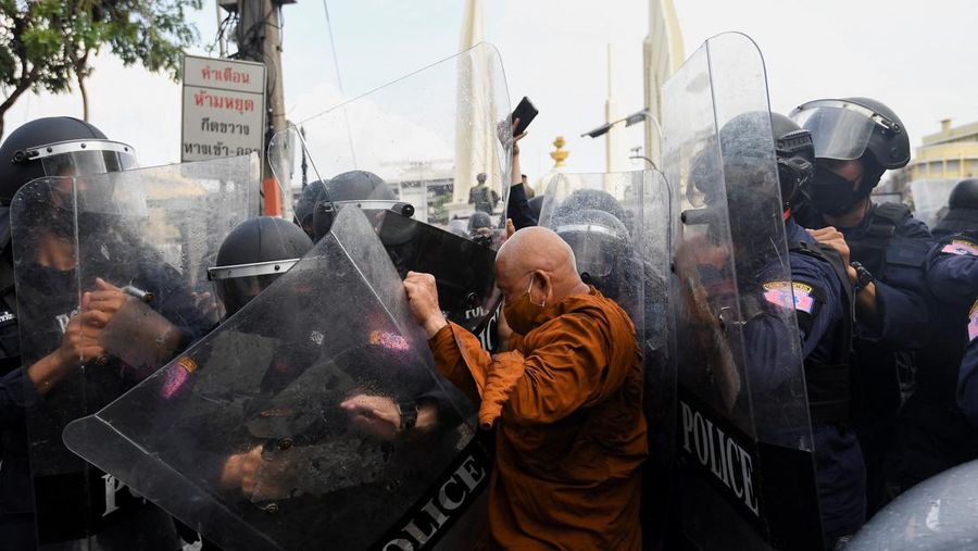 Demonstrators push a vehicle as police officers with shields stand guard near them during a protest against the Asia-Pacific Economic Cooperation (APEC) Summit 2022, near the Democracy Monument in Bangkok, Thailand November 18, 2022. REUTERS/Chalinee Thirasupa