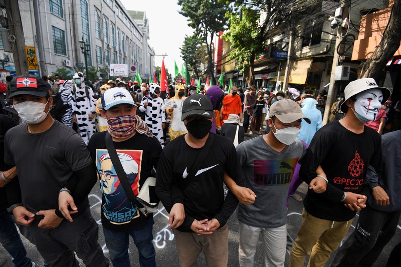Demonstrators push a vehicle as police officers with shields stand guard near them during a protest against the Asia-Pacific Economic Cooperation (APEC) Summit 2022, near the Democracy Monument in Bangkok, Thailand November 18, 2022. REUTERS/Chalinee Thirasupa