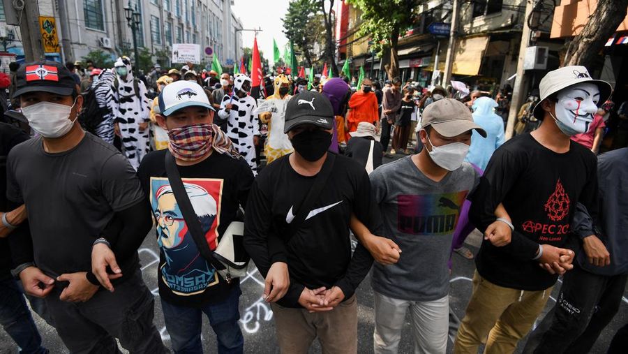 Demonstrators push a vehicle as police officers with shields stand guard near them during a protest against the Asia-Pacific Economic Cooperation (APEC) Summit 2022, near the Democracy Monument in Bangkok, Thailand November 18, 2022. REUTERS/Chalinee Thirasupa