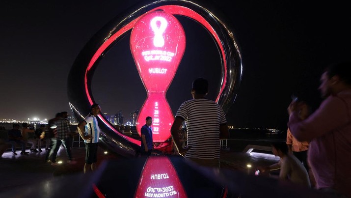 SOCCER-WORLDCUP/QATAR People take pictures next to the World Cup countdown clock ahead of the FIFA World Cup 2022 soccer tournament at the Doha Corniche, in Doha, Qatar November 14, 2022. REUTERS/Amr Abdallah Dalsh