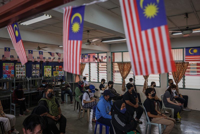 Pemilih mengantri di TPS selama pemilihan umum ke-15 di Kuala Lumpur, Malaysia, Sabtu (19/11/2022). Pemilu di Malaysia menggunakan sistem first past the post di mana partai atau koalisi yang berhasil mengantongi 112 dari total 222 kursi di parlemen akan membentuk pemerintahan. (Photo by Annice Lyn/Getty Images)