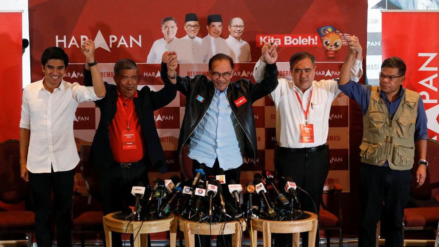 Pemimpin oposisi Malaysia Anwar Ibrahim dan pemimpin Pakatan Harapan lainnya bergandengan tangan saat konferensi pers mengenai hasil pemilihan umum Malaysia di Subang Jaya, Malaysia, Minggu (20/11/2022). Dua calon Perdana Menteri Malaysia, Anwar Ibrahim dan Muhyiddin Yassin, sama-sama mengklaim dapat membentuk pemerintahan usai pemilihan umum. (REUTERS/Hasnoor Hussain)