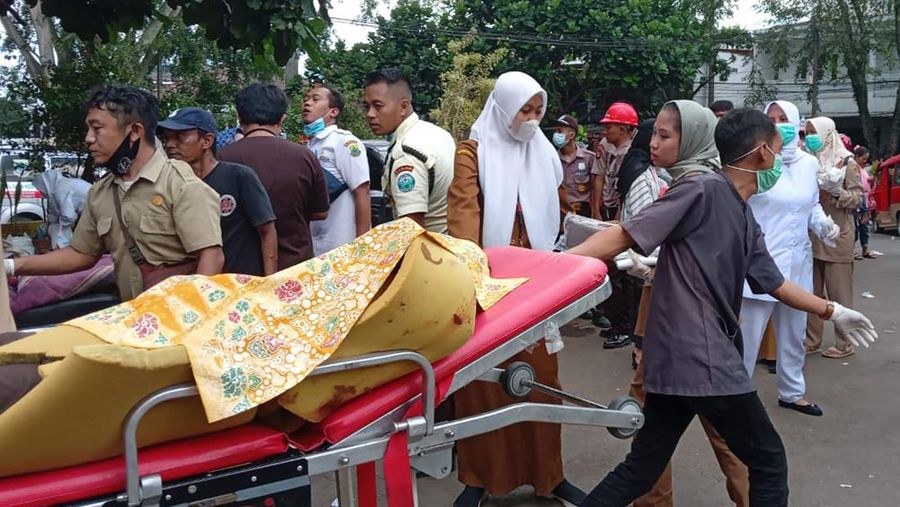 Seorang pekerja rumah sakit membawa korban gempa di atas brankar di luar sebuah rumah sakit di Cianjur, Jawa Barat, Indonesia, Senin, 21 November 2022. Gempa bumi mengguncang pulau utama Indonesia di Jawa pada hari Senin, menewaskan sejumlah orang, merusak puluhan bangunan dan mengirim penduduk ke jalan-jalan ibukota untuk keselamatan. (AP/Firman Taqur)